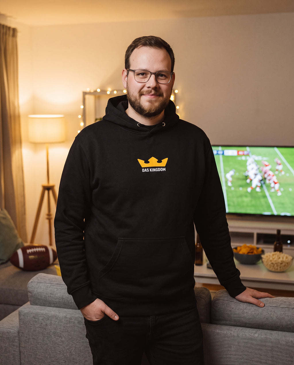 Kingdom-Host Daniel Jensen im schwarzen Das-Kingdom-Hoodie beim Gameday im Wohnzimmer